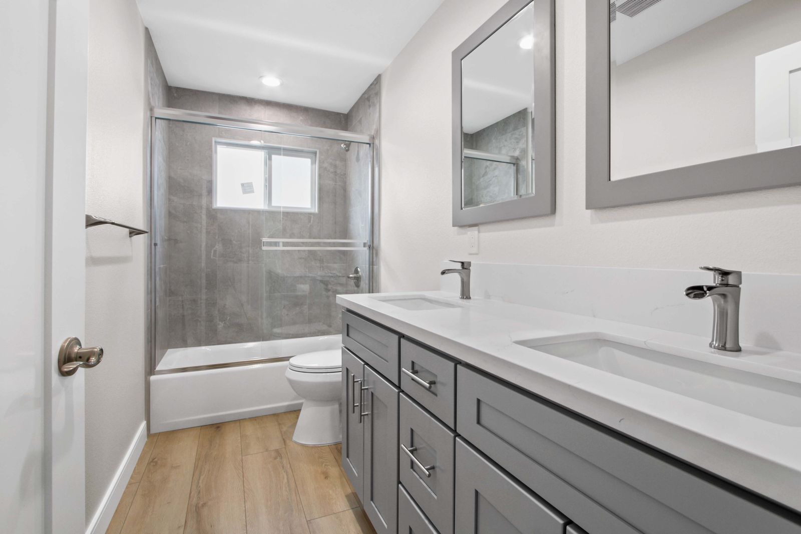 Renovated bathroom with tiled walk-in shower and dual-sink vanity