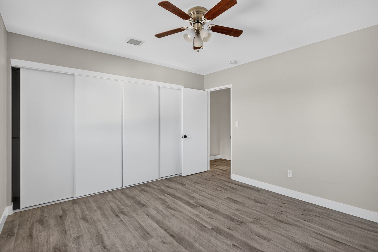 Bedroom with ceiling fan and sliding closet doors