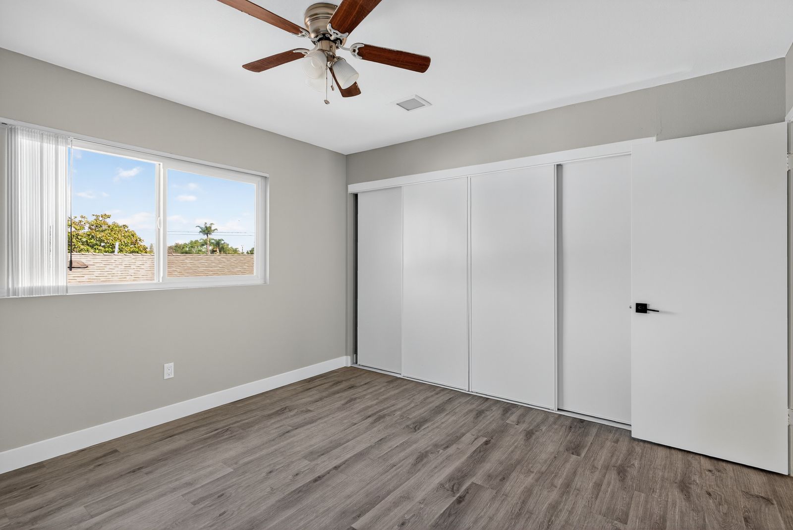Renovated bedroom with ceiling fan and view of the neighborhood