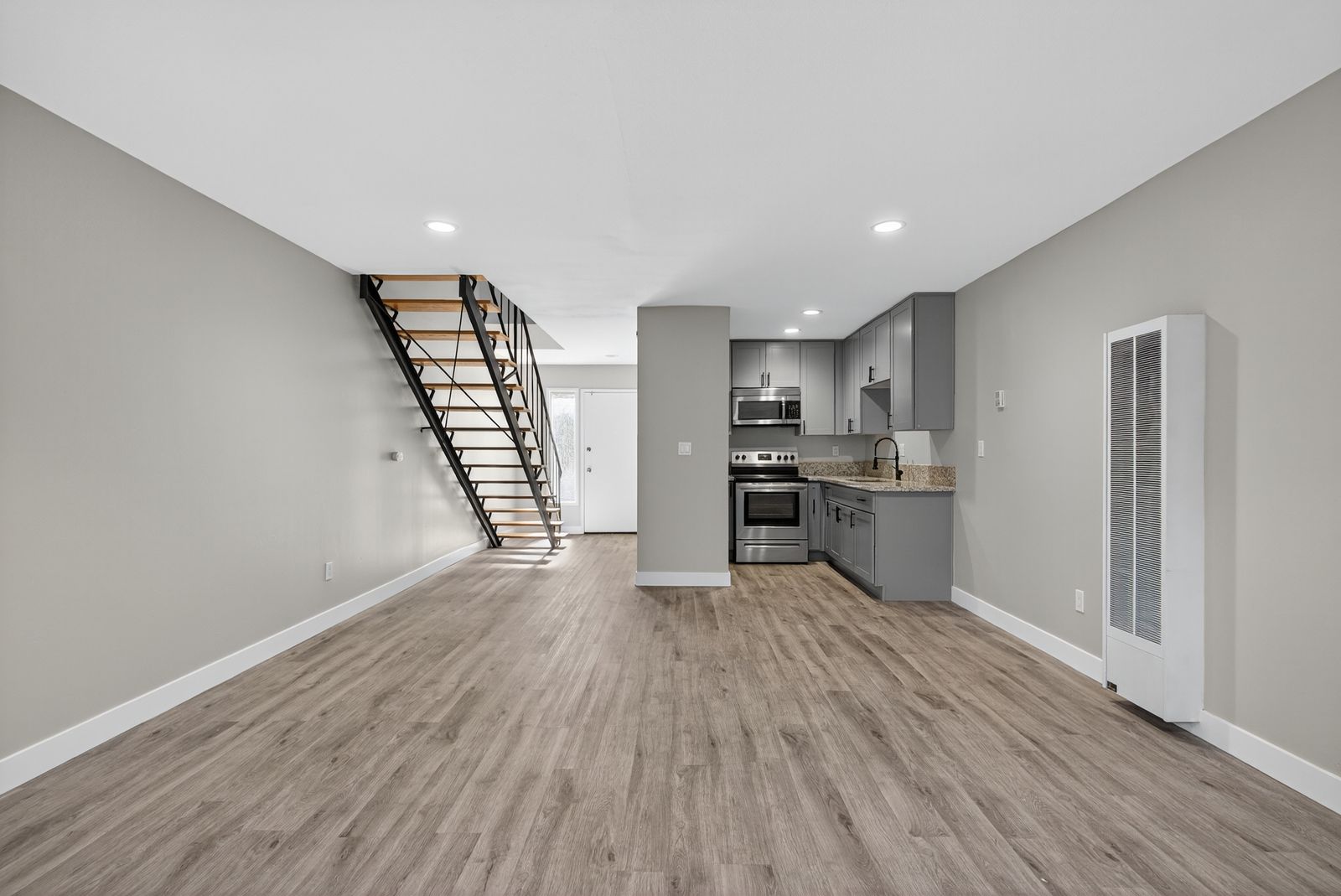 Open living area with kitchen and front entry