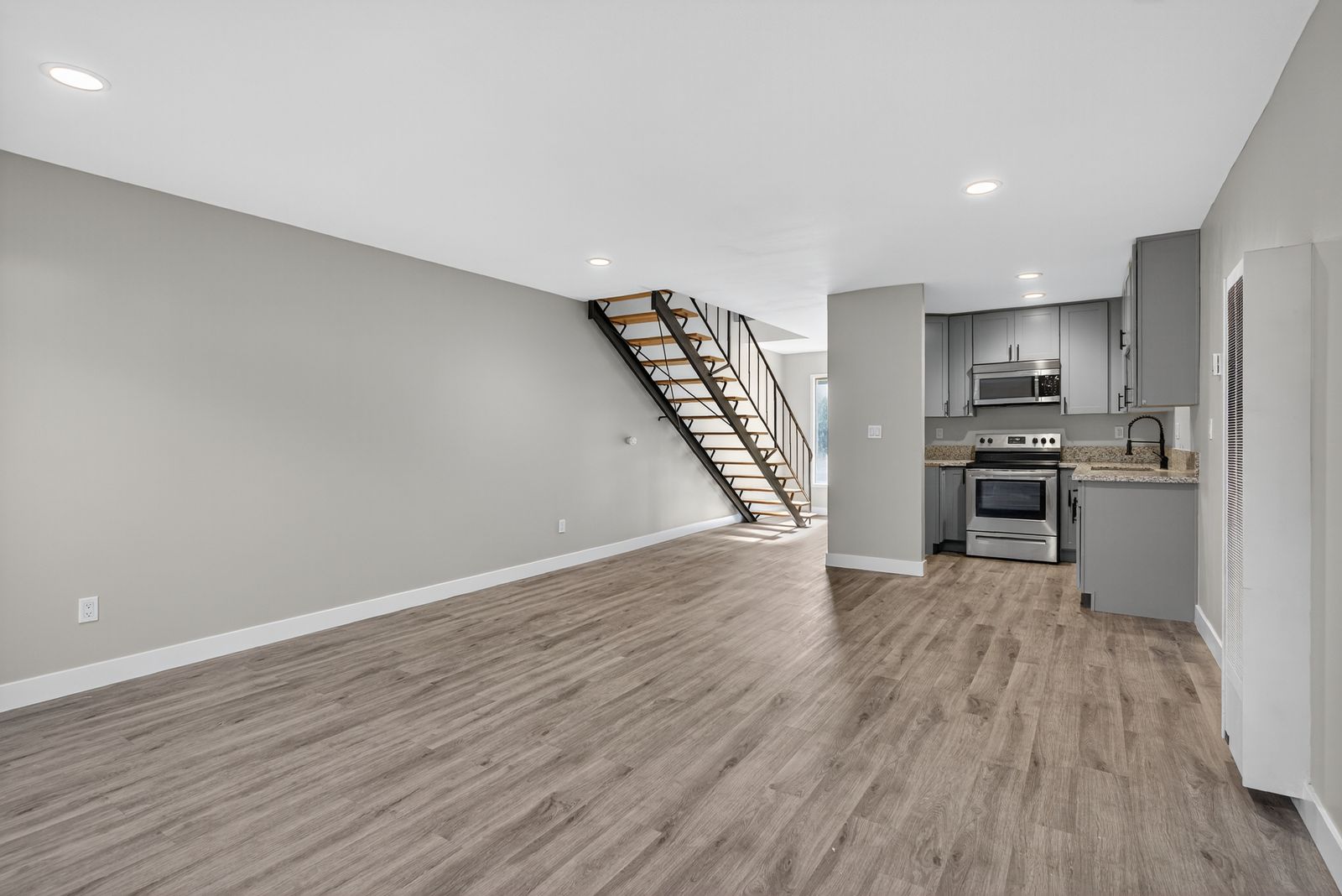 Open-concept living area with kitchen and staircase